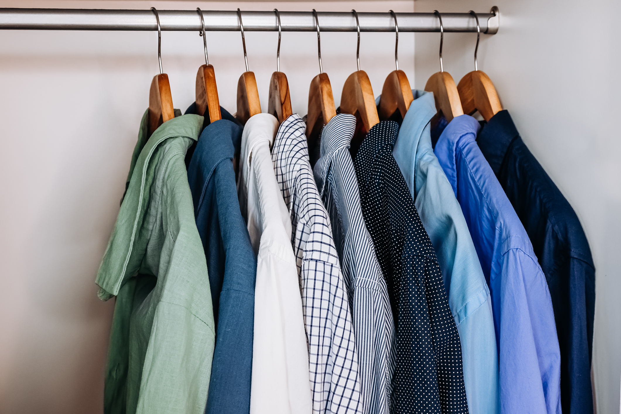 Shirts on hangers in a closet.