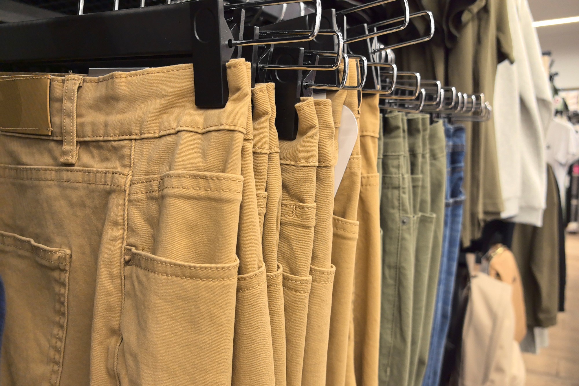 Khaki pants hanging in a clothing store.