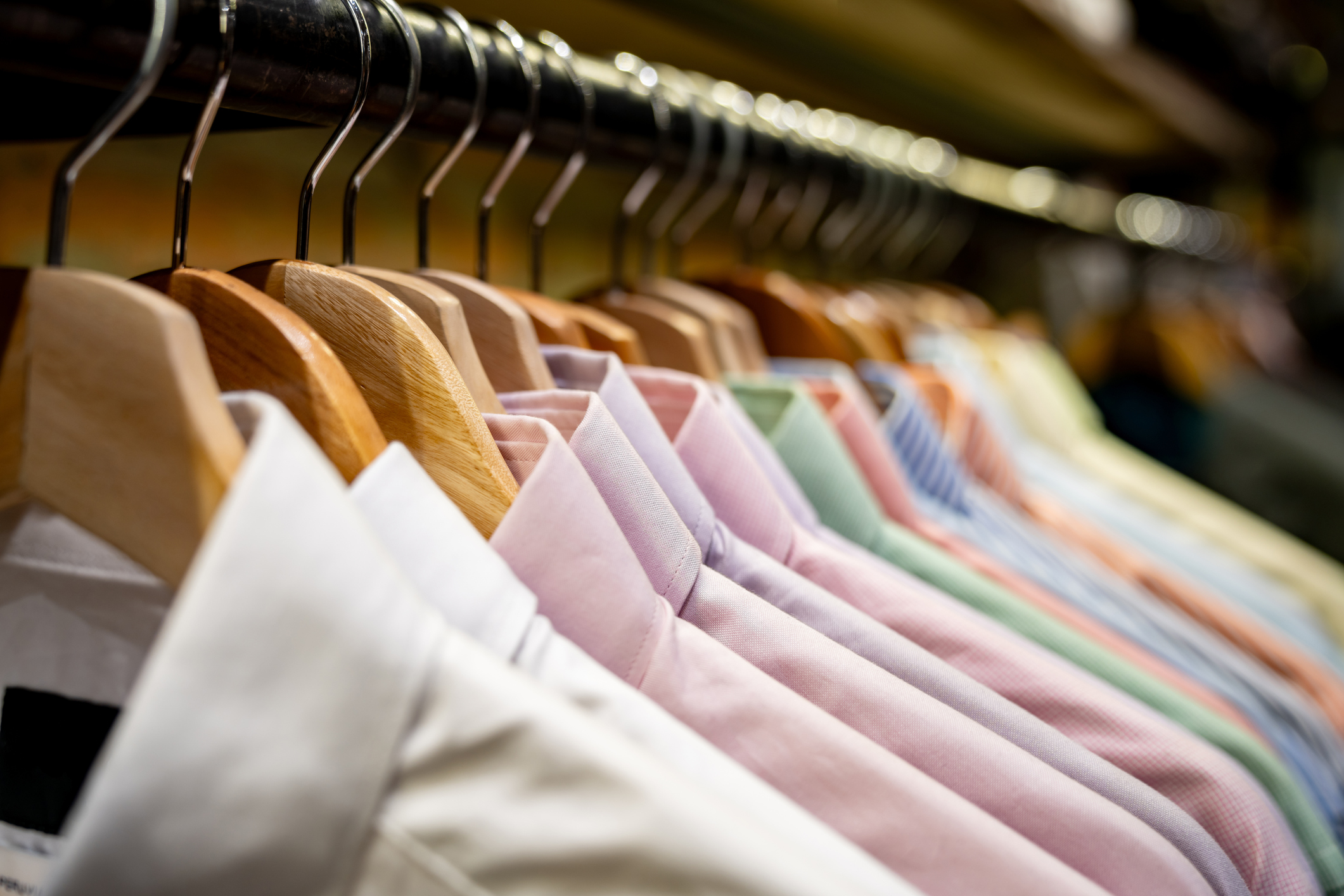 Shirts on hangers in a clothing store.