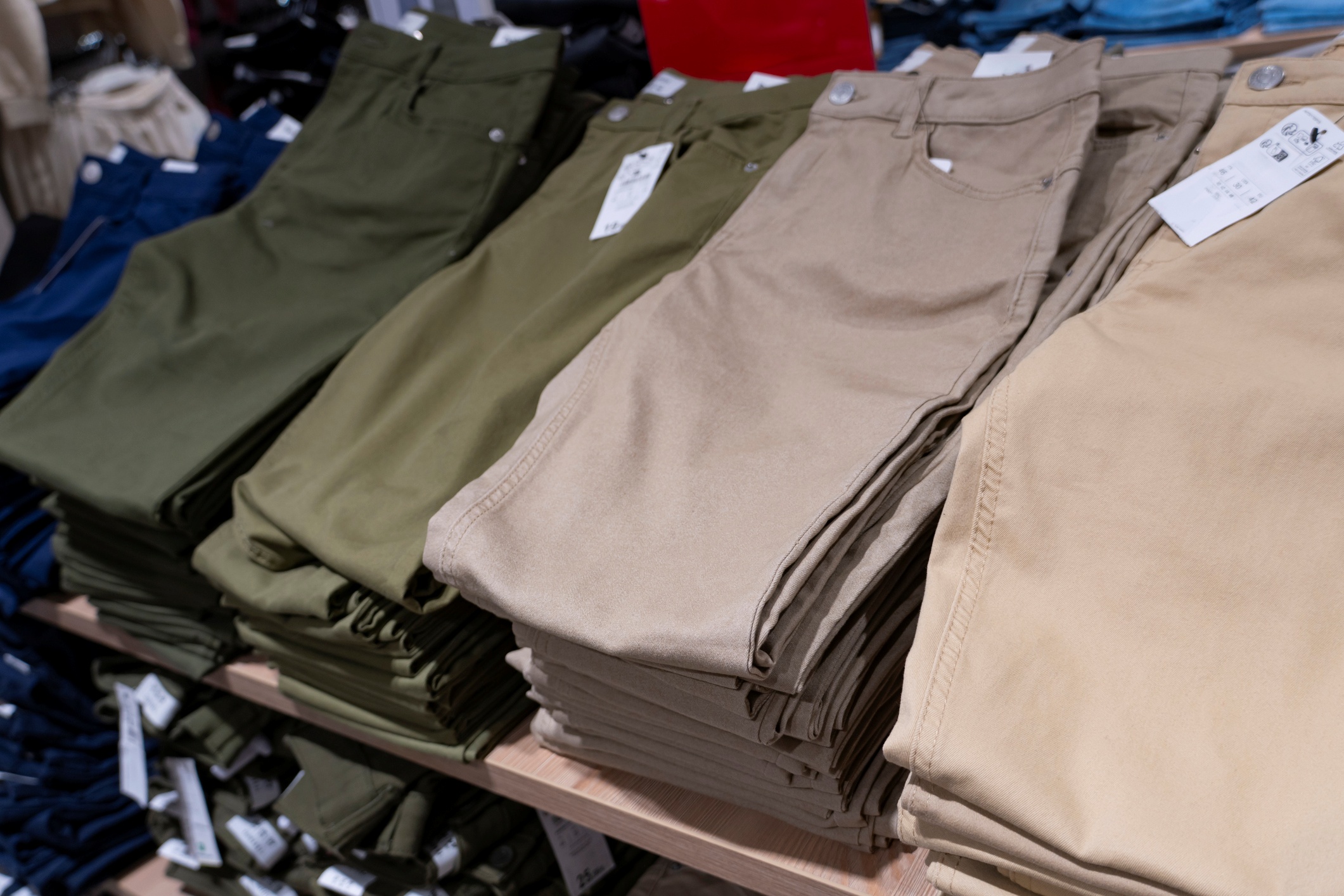 Stacked pants in various colors on display.