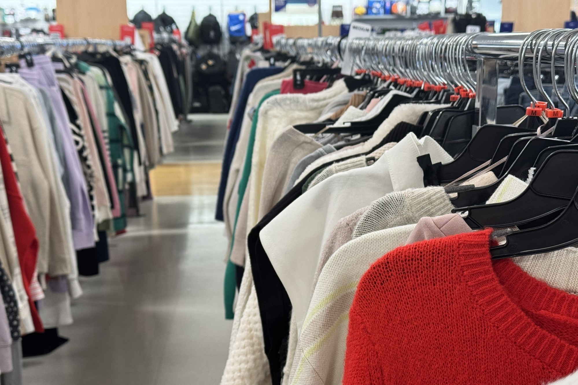 Clothing racks in a retail store aisle.