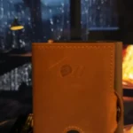 Brown leather journal by rainy window
