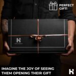 Hands holding elegant black gift box with ribbon