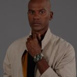 Man in beige jacket wearing wristwatch