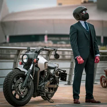 Suited man wearing helmet beside motorcycle